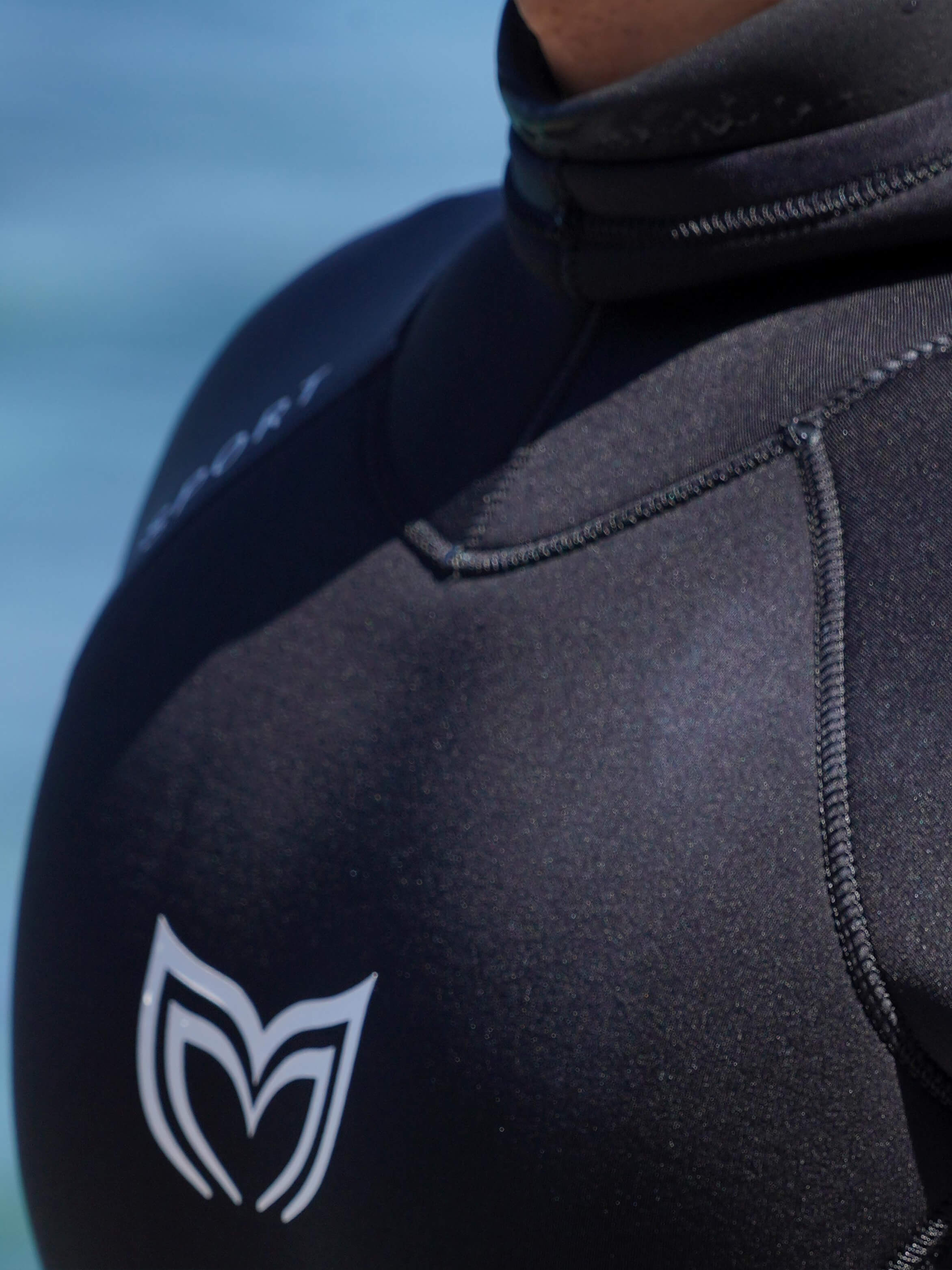 Close up of the chest logo and stitching on a mens double lined black wetsuit