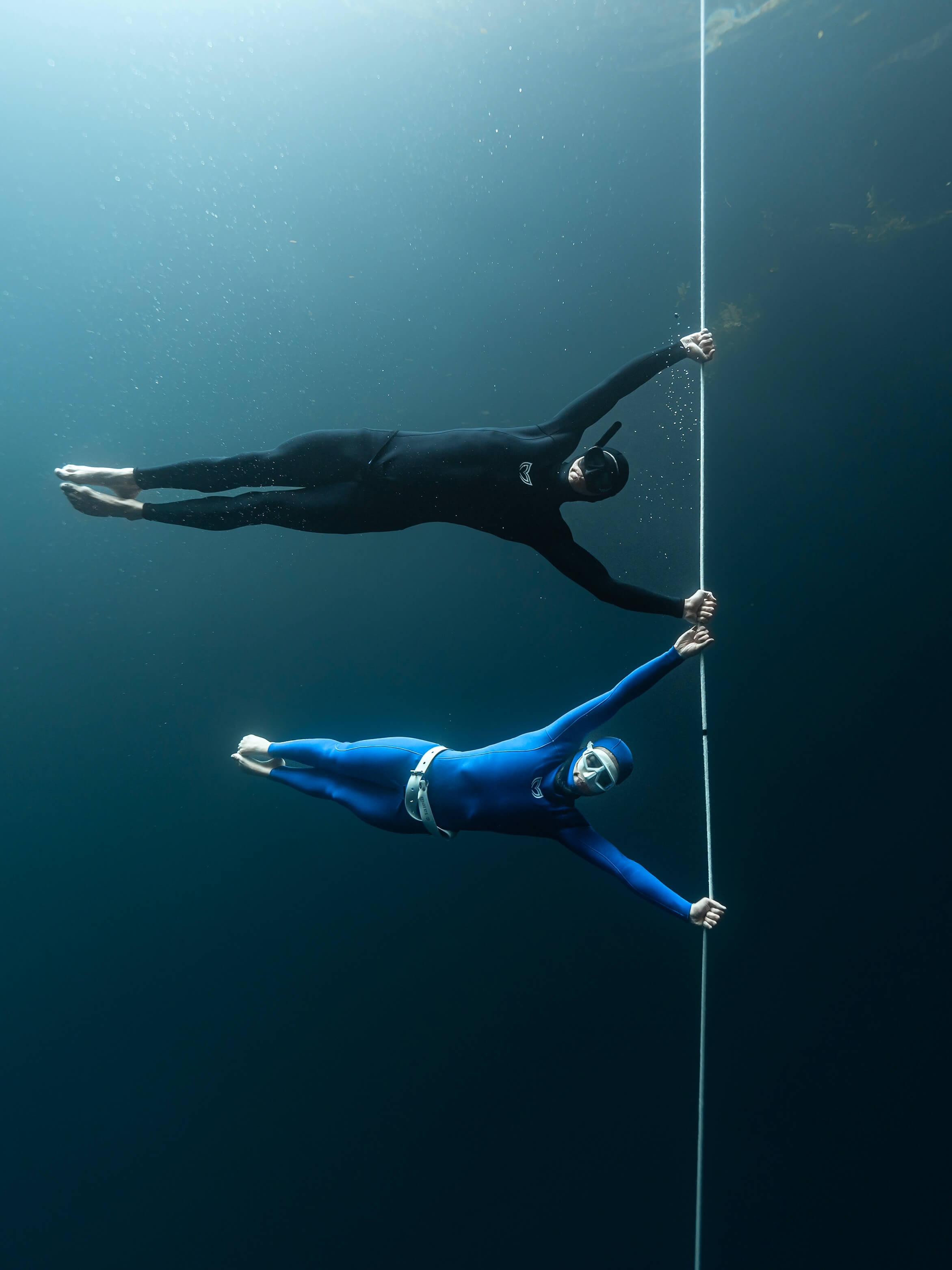 Image of a male diver ascending FIM wearing a blue 2.5mm/5mm double lined mens wetsuit