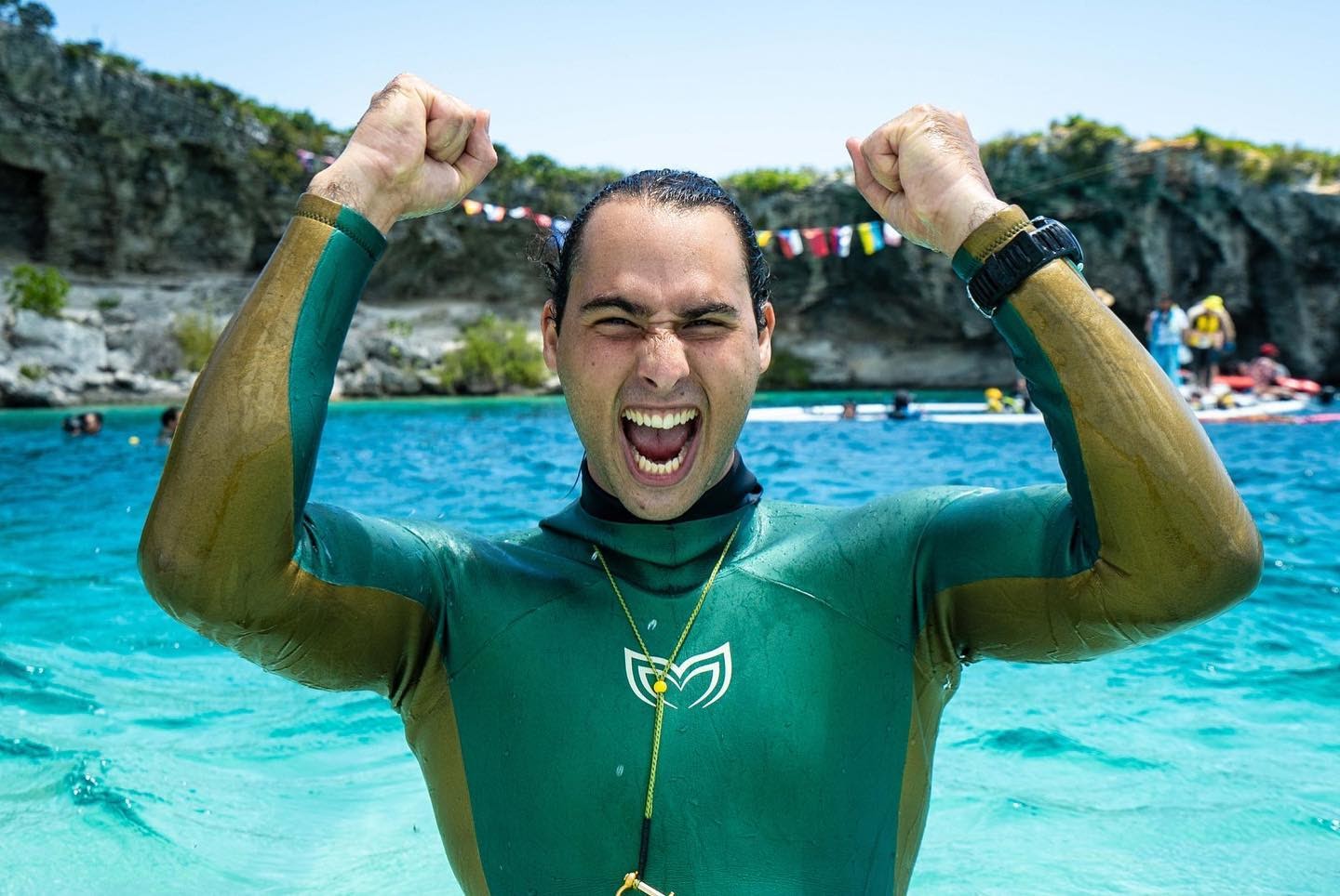 A competitive freediver celebrating while wearing a custom made freediving wetsuit.