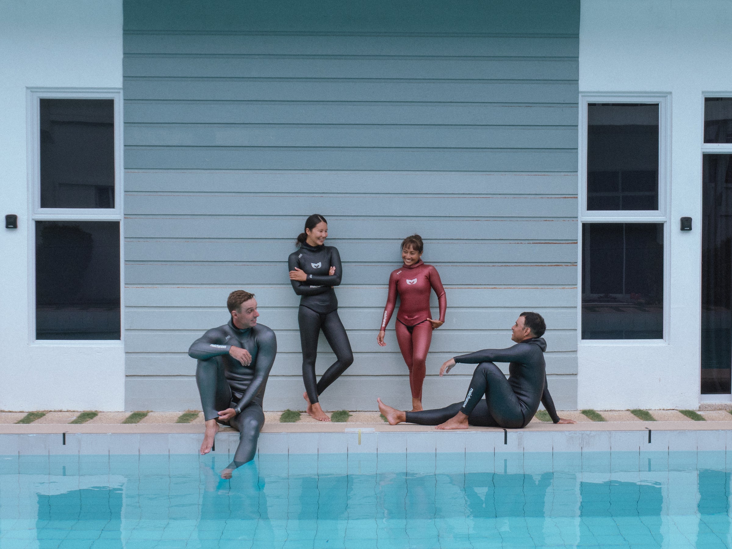 Group of four freedivers wearing Molchanovs freediving wetsuits beside a pool