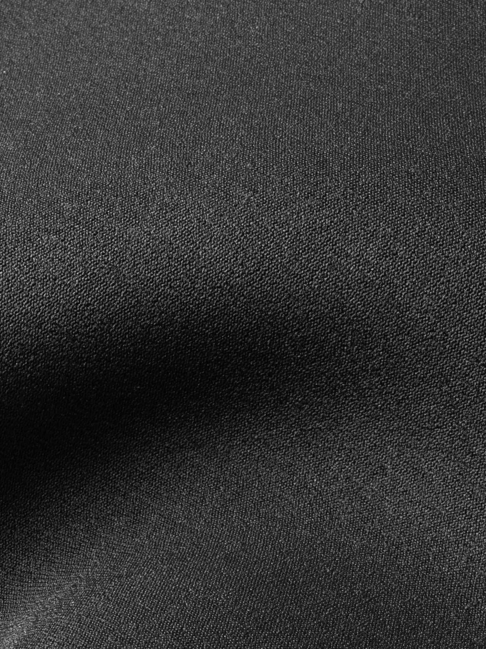 Close up showing the super stretchy lining over the neoprene for this one piece mens wet suit. Black colour and extra durable due to the double lining. 